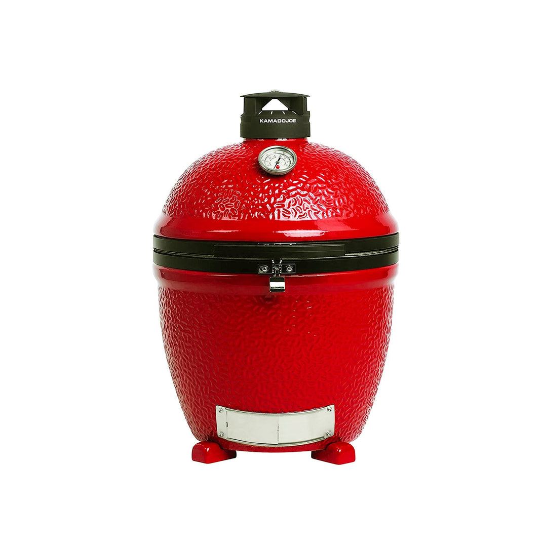 A red Kamado Joe grill with chrome draft door at the bottom of the base, black metal bands with latch where the grill body and lid meet, a thermometer in the top of the lid, and a Kontrol Tower top vent.
