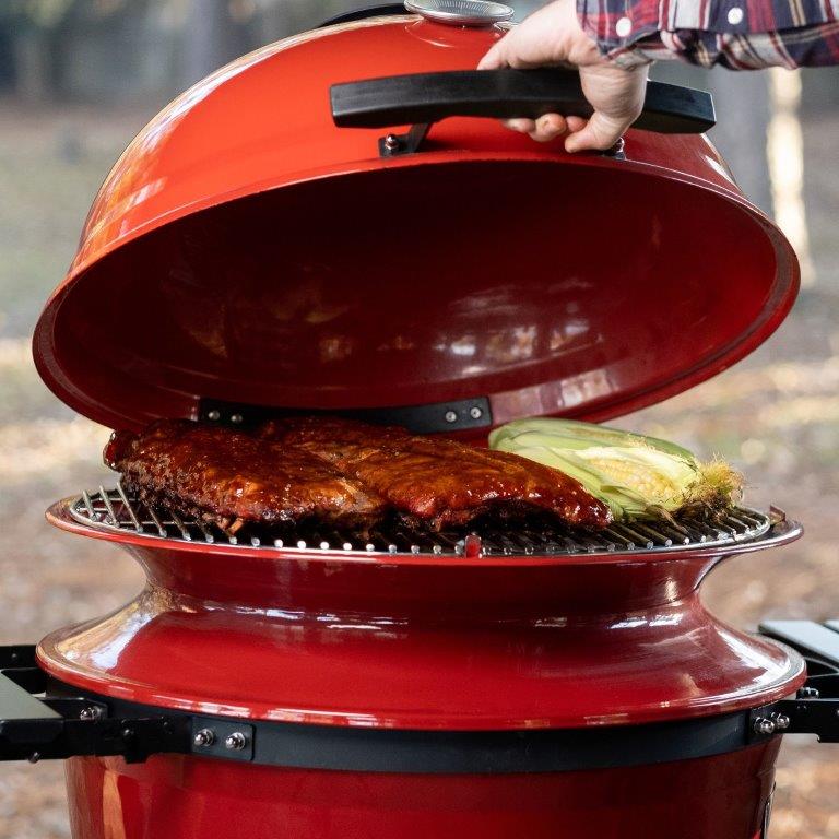 Closing the grill lid on ribs and corn on the SlōRoller™