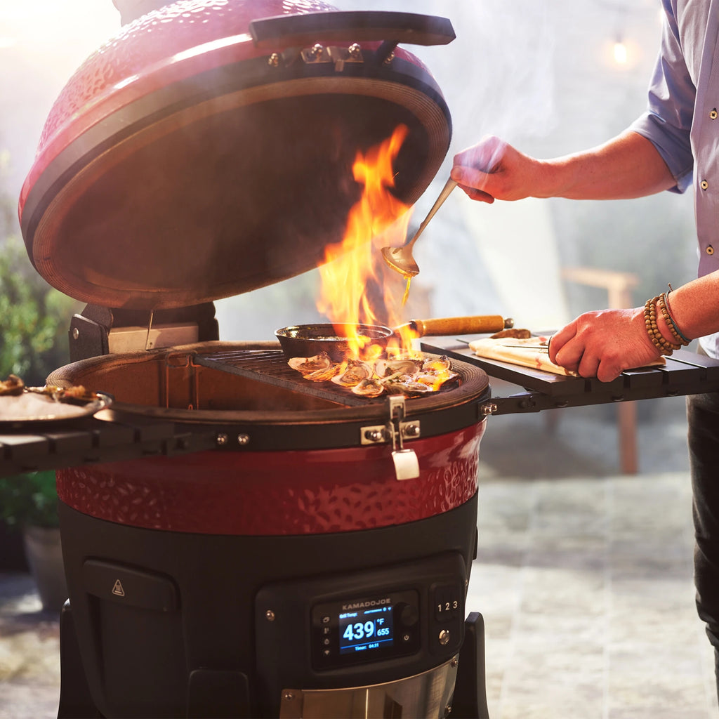 A man drizzles a sauce over grilling oysters to flambe them