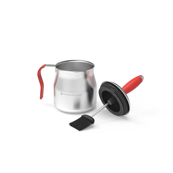 Steel basting pot with red handle sitting next to the combined brush/pot lid all against a white background.