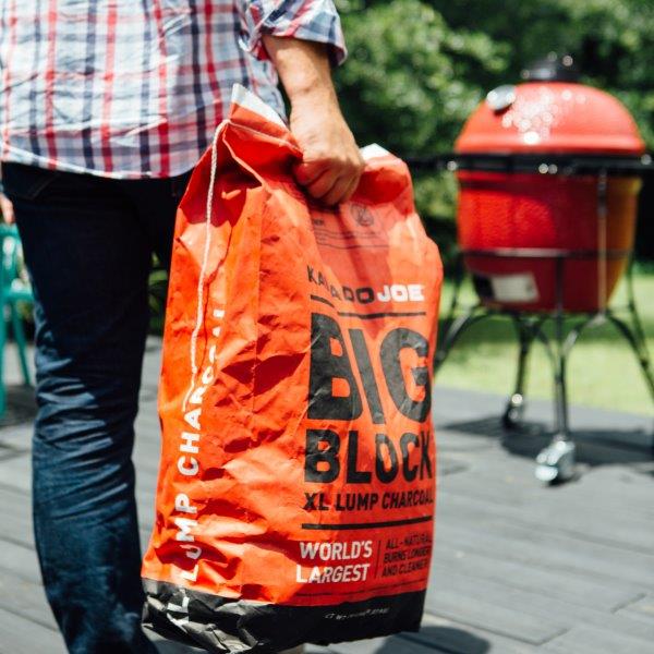 Carrying a back of charcoal to the grill