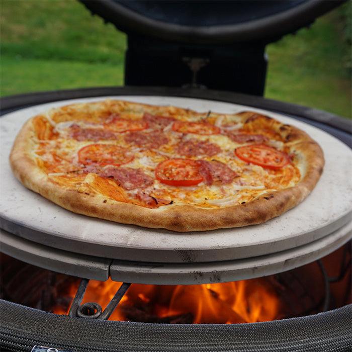 A pizza being cooked in the grill using a Kamado Joe Pizza Stone