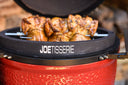 The JoeTisserie installed on the grill showing how the support sits firmly on the grill body